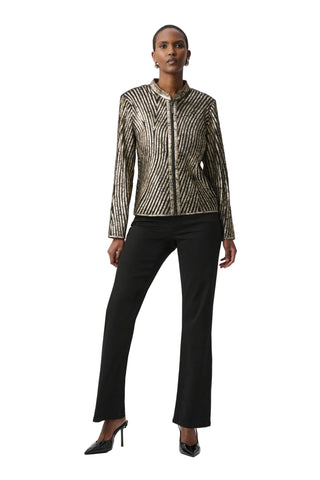 Woman wearing a patterned jacket and black pants on a white background