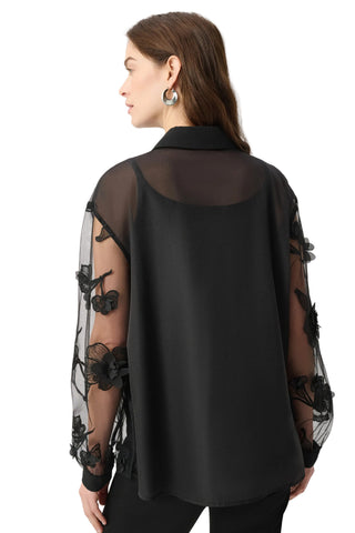 Black blouse with sheer sleeves and floral details on a white background