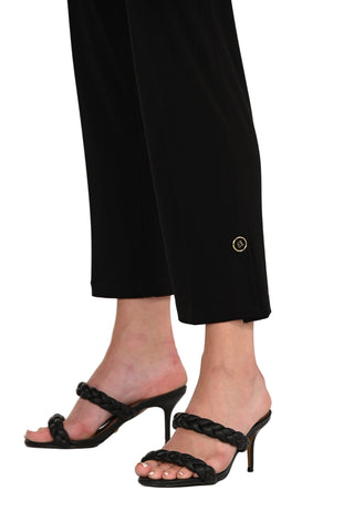 Black high-heeled sandals worn with black pants on a white background