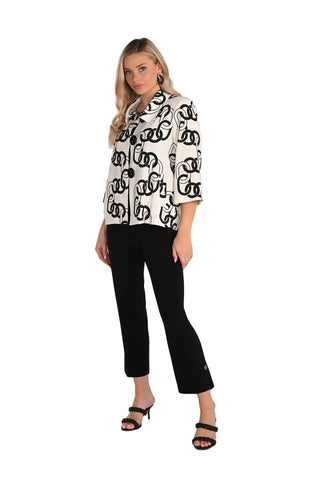 Woman wearing a black and white patterned blouse with black pants on a white background