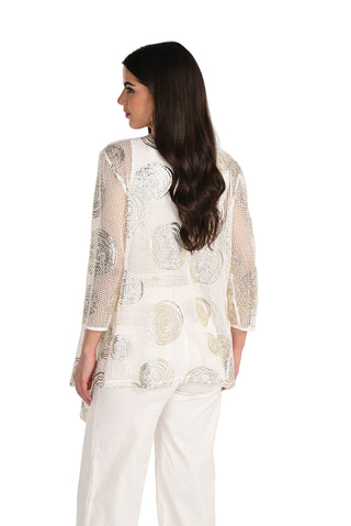 Woman wearing a sheer top with intricate patterns on a white background