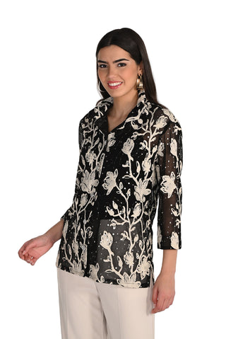 Woman wearing a black floral patterned blouse on a white background
