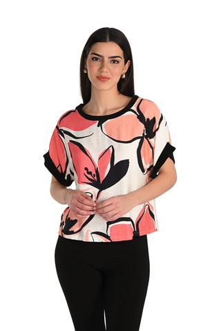 Woman wearing a floral-patterned top with black accents on a white background