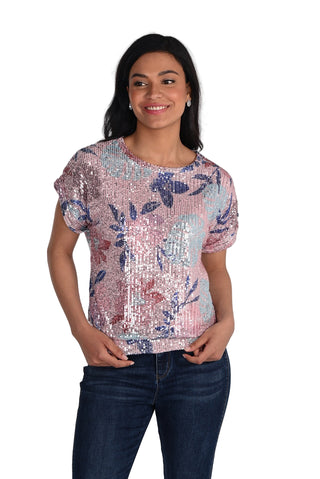 Woman wearing a sequined floral top and jeans on a white background