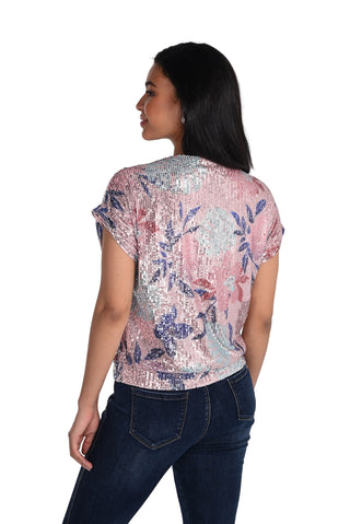 Woman wearing a sequined top with floral pattern on a white background