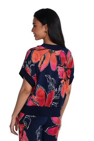 Woman wearing a navy blue outfit with red floral patterns on a white background