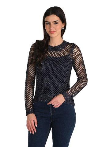 Woman wearing a black fishnet top and jeans on a white background