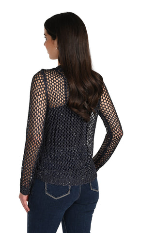 Woman wearing a black mesh long-sleeve top and blue jeans on a white background