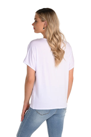 Woman wearing a white t-shirt and blue jeans on a plain background