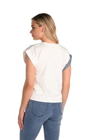 Woman wearing a white t-shirt with blue sleeves and blue jeans on a plain background