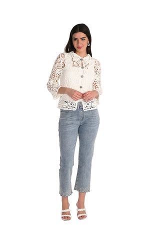 Woman wearing a white lace blouse and blue jeans on a white background