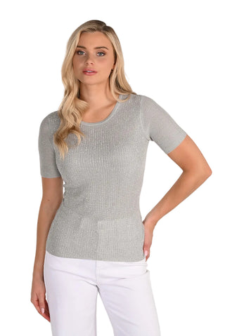 Woman wearing a gray short-sleeve top and white pants on a white background