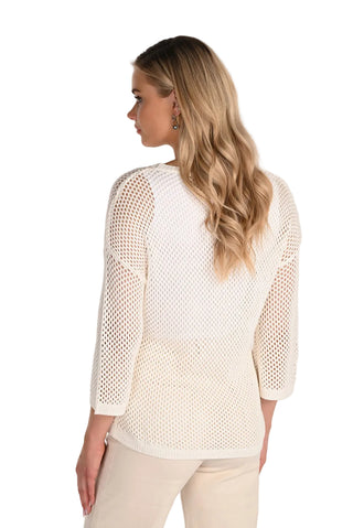 Woman wearing a white mesh top against a plain background