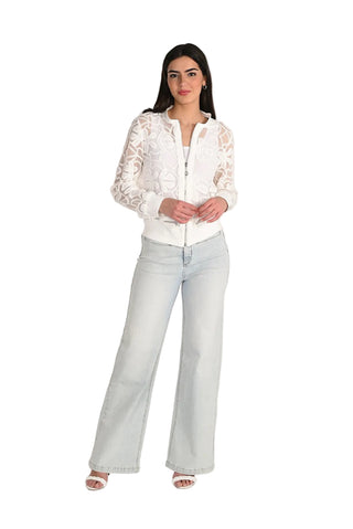 Woman wearing a white lace blouse and light blue jeans on a white background