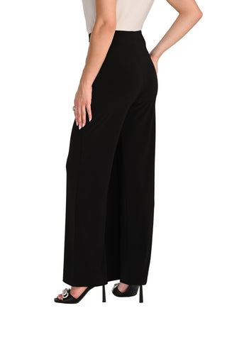 Person wearing black wide-leg pants on a white background