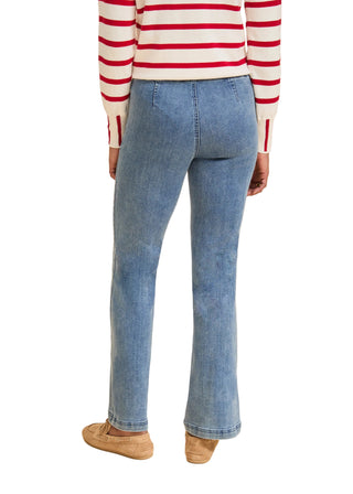 Person wearing a red and white striped sweater and blue jeans on a beige background