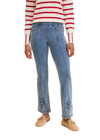 Person wearing a red and white striped sweater with blue jeans on a beige background