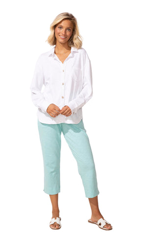 Woman wearing a white shirt and light blue pants against a white background