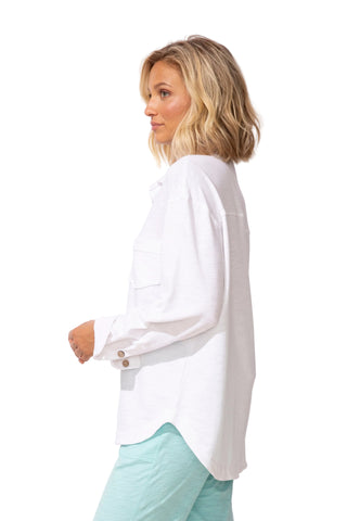 Woman wearing a white blouse with long sleeves on a plain background