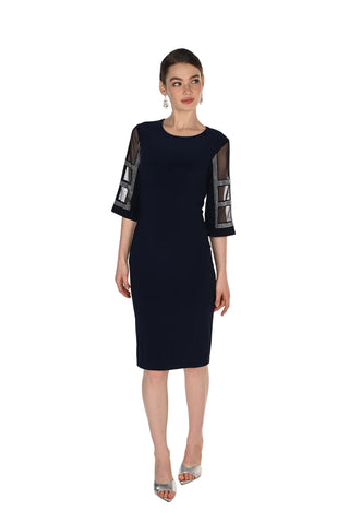 A woman modeling a dark navy blue knee-length dress with three-quarter sleeves featuring sheer mesh panels and geometric silver embellishments, set against a plain white studio background.