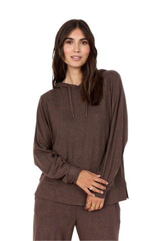 Woman wearing a brown hoodie and pants on a white background
