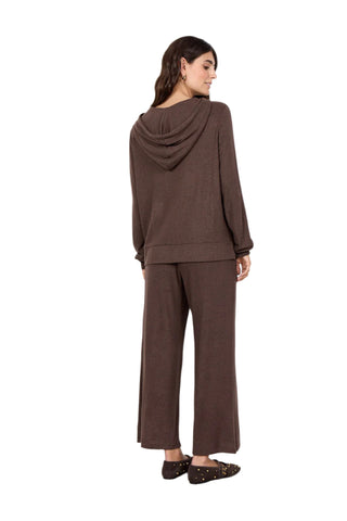 Woman wearing a brown outfit with a matching jacket and pants on a white background