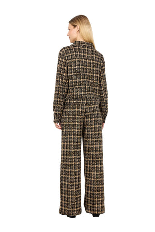 Person wearing a houndstooth patterned suit standing against a white background