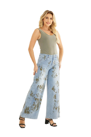 Woman wearing a green tank top and floral jeans standing in a living room.