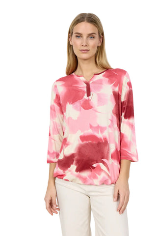 woman wearing  pink and cream top  with white background