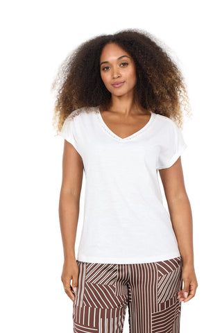 Woman wearing a white t-shirt and patterned pants on a white background