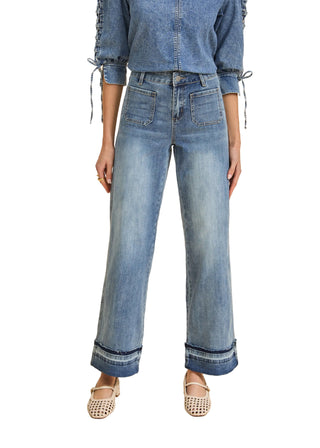 Person wearing a denim outfit on a beige background