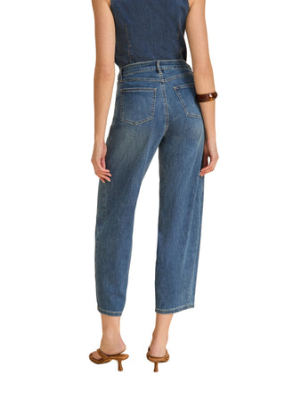 Person wearing blue jeans on a beige background