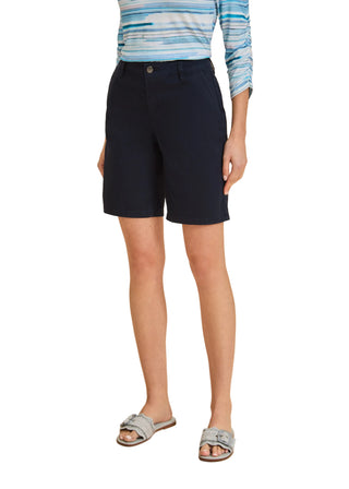 Person wearing navy shorts and a striped shirt on a beige background