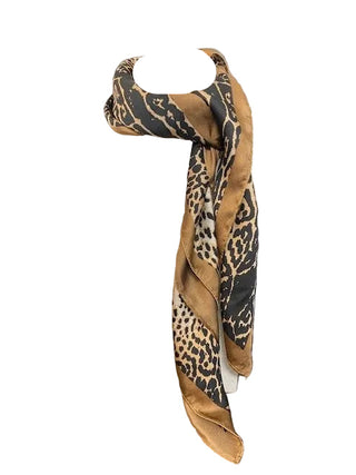 Leopard print scarf draped over a white cylindrical object on a dark surface
