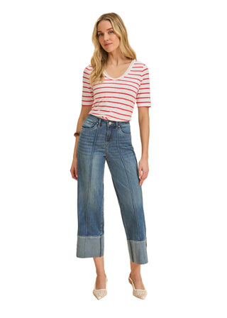 Woman wearing a striped shirt and jeans on a beige background