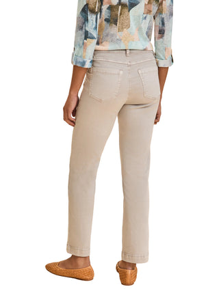 Person wearing light-colored pants and a patterned shirt on a beige background