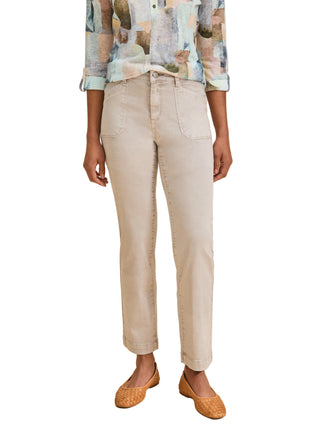 Person wearing beige pants and a patterned shirt on a beige background