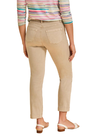 Person wearing beige pants and a colorful striped shirt on a beige background