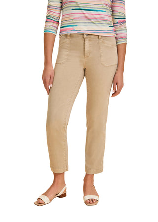 Woman wearing beige pants and a striped shirt on a beige background