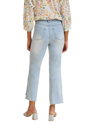 Light blue jeans worn by a person on a beige background