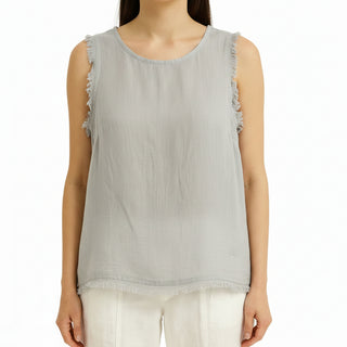White sleeveless top worn by a person on a white background