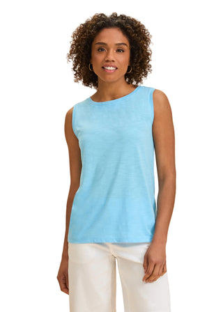 Woman wearing a light blue sleeveless top against a beige background