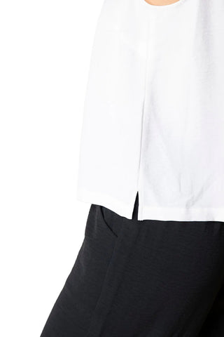 White top and black pants on a beige background