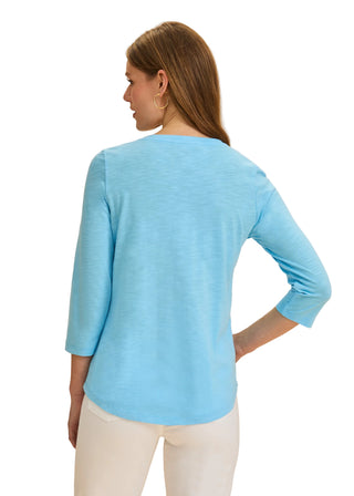Woman wearing a light blue sweater against a beige background