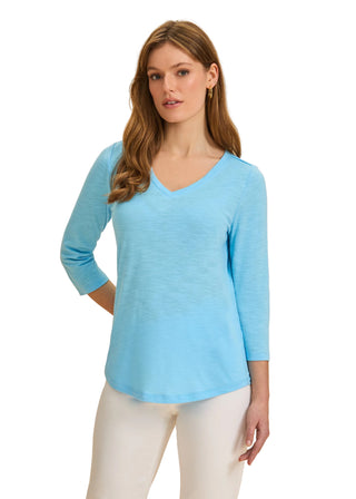 Woman wearing a light blue sweater with a beige background