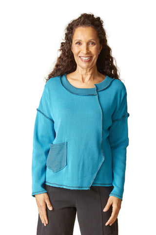 Woman wearing a blue sweater with a textured pattern on a beige background