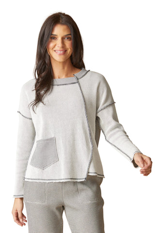 Woman wearing a gray sweater and pants on a beige background