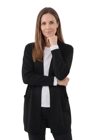A woman modeling a black open-front cardigan over a white top, standing against a light gray studio background.