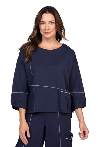 Woman wearing a navy blue outfit with a plain background