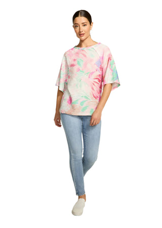 Woman wearing a tie-dye shirt and jeans on a white background